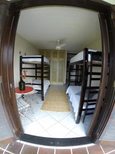um quarto com 2 beliches e uma mesa em Hostel House 84 em Itajaí