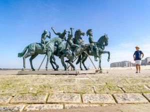 a statue of people riding horses on the beach at Apartment on Belgian Coast with Sea View in De Haan
