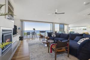 Una sala de estar con un sofá azul y una chimenea. en Quarterdeck, en Dromana