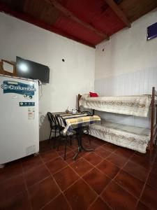 a small room with a table and a refrigerator at Hospedaje La Terminal in La Porteña