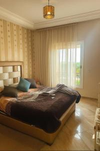 a bedroom with a large bed and a window at Ricoflores PALM in O Ben Slimane