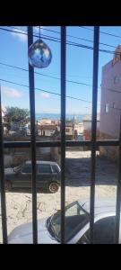 a window with a view of a parking lot with a car at Solemarciano in São Thomé das Letras