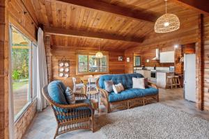 Una sala de estar con un sofá y sillas y una cocina. en Barefoot Bungalow, en Quindalup