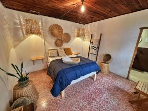 a bedroom with a bed with a blue comforter at Hotel Neutro in San Cristóbal de Las Casas +18 photos
