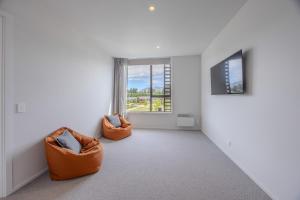 une chambre avec deux chaises orange et une fenêtre dans l'établissement Luxurious Townhouse Just Minutes From Lake Wanaka, à Wanaka