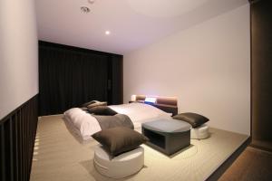 a bedroom with a bed with two pillows and a table at Princes Princes Shiojirikita in Matsumoto