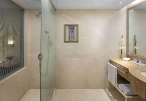 a bathroom with a glass shower and a sink at Radisson Blu Hotel Shanghai New World in Shanghai