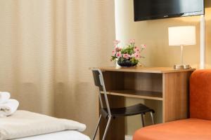 a hotel room with a desk with flowers on it at Hotel Pankow in Berlin