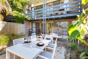 a white table and chairs on a patio at Casa Corallo in Airlie Beach