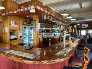 eine Bar mit einer großen Holztheke in einem Restaurant in der Unterkunft Apsley Arms hotel in Walcha + 14 Fotos
