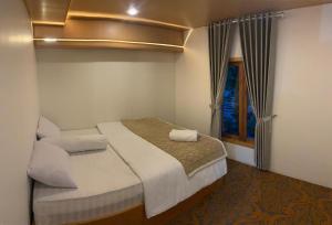 a small bedroom with a bed and a window at Platinum Cabin Dieng 3 by Horison in Diyeng