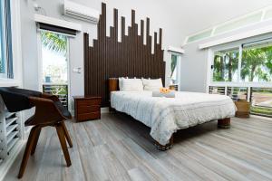 a bedroom with a large bed and a chair at Paradis Sur Terre Ocean View Fiji Villa for 12 with 2 Private Pools in Lauwaki