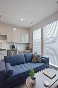 a living room with a blue couch and a table at CozySuites Spacious SDO, Lawrenceville in Pittsburgh