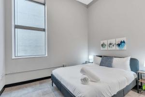 ピッツバーグにあるCozySuites Modern 1BR in Downtown Pitts #14の大きなベッドと窓のある白い寝室