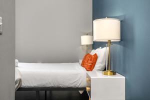 ピッツバーグにあるCozySuites Modern 1BR in Downtown Pitts #1のベッドルーム1室(ナイトスタンドにランプ付)