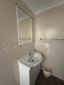 ein weißes Badezimmer mit Waschbecken und Spiegel in der Unterkunft Apsley Arms hotel in Walcha