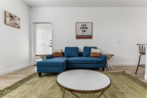 Una sala de estar con un sofá azul y una mesa. en CozySuites Glendale by the stadium with pool 20, en Glendale