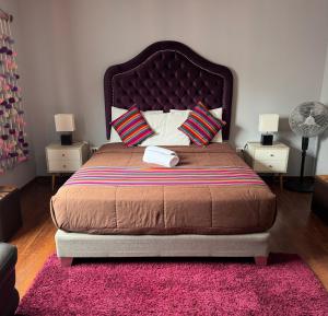 a bedroom with a large bed with a pink rug at The Lighthouse Bed and Breakfast in Lima