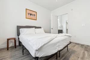 a bedroom with a large bed with white sheets at CozySuites Glendale by the stadium with pool 28 in Glendale