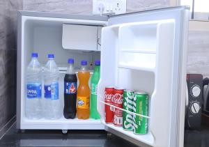 an open refrigerator filled with drinks and soda at Royalpark resort in Jāmb