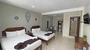 a hotel room with two beds and a bathroom at Hotel Balxibá alberca y estacionamiento in Playa del Carmen