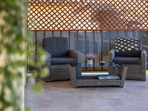 two chairs and a table on a patio at Maison neuve à Sarlat avec jardin et terrasse - FR-1-616-488 in Sarlat-la-Canéda