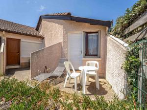 a patio with two chairs and a table and chairs at Mimizan Plage Sud : Bel appartement pour 4, proche océan, parking privatif - Ménage inclus - FR-1-50-183 in Mimizan +7 photos