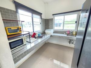 a kitchen with a sink and a microwave at Pool Villa - Phetchabun in Ban Yawi +10 photos
