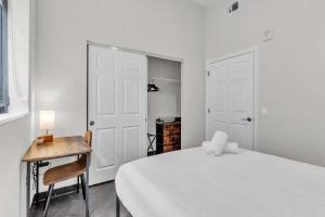 a bedroom with a bed and a desk and a chair at CozySuites Modern 1BR in Downtown Pitts #22 in Pittsburgh