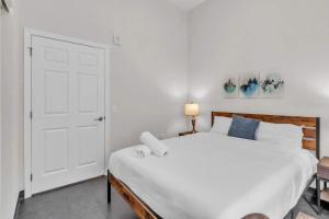 a bedroom with a large white bed and a door at CozySuites Modern 1BR in Downtown Pitts #22 in Pittsburgh +14 photos