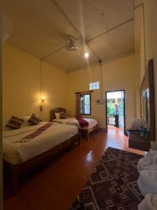 Una habitación de hotel con dos camas y un pasillo. en Meexai Guesthouse, en Nongkhiaw
