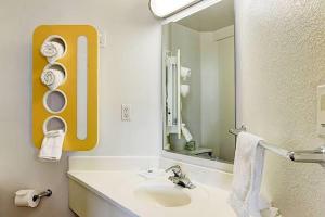 a bathroom with a sink and a large mirror at Super 8 by Wyndham Aurora East in Aurora