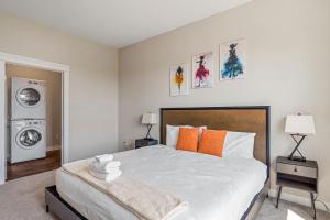 a bedroom with a bed and a washing machine at CozySuites - Penrose On Mass with pool & parking #2 in Indianapolis