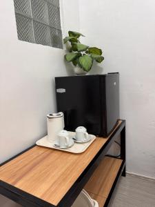 a table with two cups and a tv on it at Comfy 2Single Beds Unit, with Wifi, Free Parking at Sonia's Island Stay in Virac