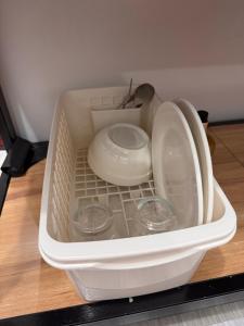 a white container with two plates and bowls in it at Comfy 2Single Beds Unit, with Wifi, Free Parking at Sonia's Island Stay in Virac +24 photos