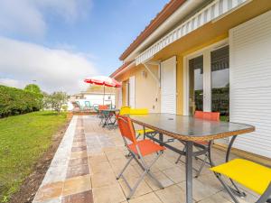 a patio with a table and chairs and an umbrella at Maison à Mimizan avec jardin et piscine privée pour 6 personnes - FR-1-50-95 in Mimizan