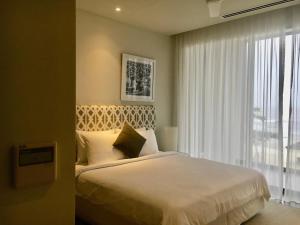 a bedroom with a bed and a large window at SANCTUARY HỒ TRÀM RESORT - Near beach in Ho Tram +20 photos