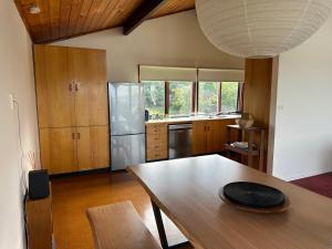 a kitchen with a wooden table and a kitchen with a refrigerator at Eden Niu in Eden