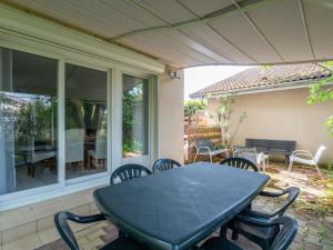 a black table and chairs on a patio at Maison Charmante 3* à Mimizan: Plages, Pistes Cyclables, Jardin, Wi-Fi, pour 8 Personnes - FR-1-50-137 in Mimizan +7 photos