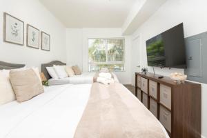 a white bedroom with a large bed and a couch at Hollywood Cozy Apartment in Los Angeles