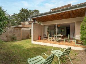 a patio with chairs and a table in a yard at Maison 3* à Mimizan Plage, proche Courant, 6 pers, 800m des plages, parkings, wifi, ménage inclus - FR-1-50-82 in Mimizan
