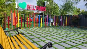 a playground with a yellow bench in front of a fence at Bell Farms and Resorts in Munroe Island