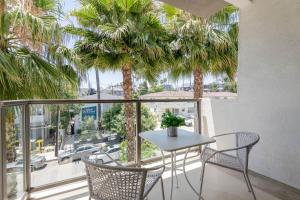 a table and chairs on a balcony with palm trees at Hollywood Cozy Apartment in Los Angeles +18 photos
