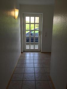 ein leeres Zimmer mit einer Tür und Fliesenboden in der Unterkunft 4-Zimmer Apartment auf Resthof in Halver