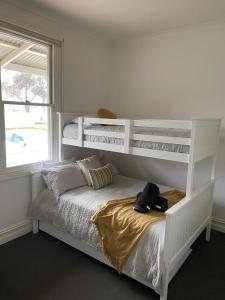 a bedroom with a white bunk bed and a window at Spacious self contained house walking distance-CBD in Bendigo