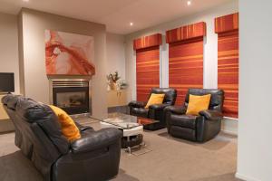 吉朗Stylish Retreat Steps from Geelong Waterfront, with Parking, Wi-Fi, AC的客厅配有真皮座椅和壁炉