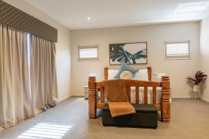 吉朗Stylish Retreat Steps from Geelong Waterfront, with Parking, Wi-Fi, AC的一间卧室设有木床和窗户。