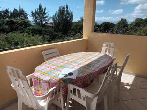 a table and chairs sitting on a balcony with a table and a table and chairs at Chez Janou (sci sijimad) in Sainte-Anne