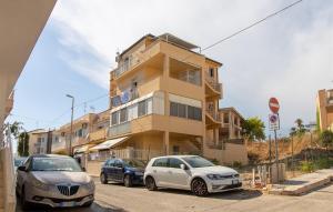 Dos coches aparcados delante de un edificio en Sunshine House, en Marina di Ragusa