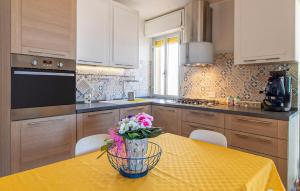 Una cocina con una mesa con un jarrón de flores encima. en Sunshine House, en Marina di Ragusa